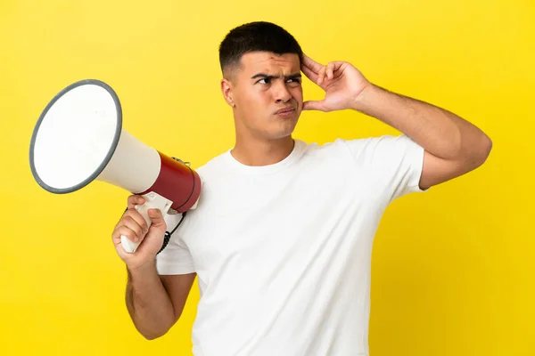 Joven Hombre Guapo Sobre Fondo Amarillo Aislado Sosteniendo Megáfono Teniendo —  Fotos de Stock