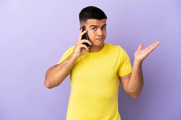 Joven Hombre Guapo Usando Teléfono Móvil Sobre Fondo Púrpura Aislado —  Fotos de Stock