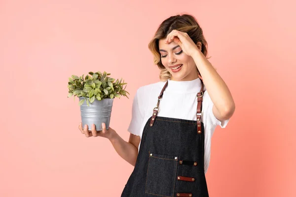 Ragazza Giardiniere Russo Possesso Una Pianta Isolata Sfondo Rosa Ridere — Foto Stock