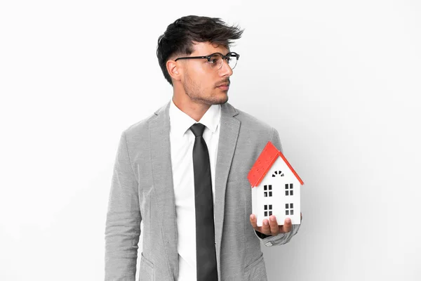 Uomo Affari Possesso Una Casa Isolata Sfondo Blu Guardando Lato — Foto Stock