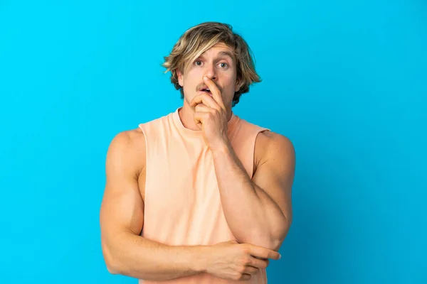 Bonito Homem Loiro Isolado Fundo Azul Surpreso Chocado Enquanto Olha — Fotografia de Stock