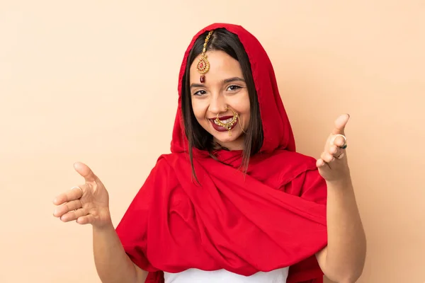 Mladá Indická Žena Izolované Béžové Pozadí Prezentovat Zvoucí Přijít Rukou — Stock fotografie
