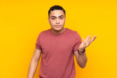 Asyalı yakışıklı adam sarı arka planda izole edilmiş geliyor.