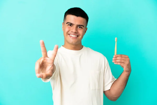 Jovem Homem Bonito Escovando Dentes Sobre Fundo Azul Isolado Sorrindo — Fotografia de Stock