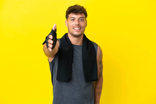 Junger Sportkaukasier Mit Handtuch Auf Gelbem Hintergrund Der Hände Schüttelt — Stockfoto