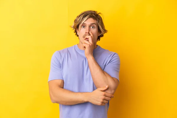 Hombre Guapo Rubio Aislado Sobre Fondo Amarillo Sorprendido Sorprendido Mientras —  Fotos de Stock