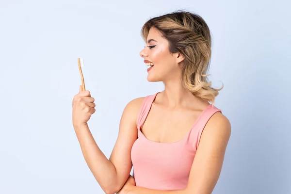 Dişlerini Fırçalayan Genç Kız Mutlu Bir Ifadeyle Mavi Arka Planda — Stok fotoğraf