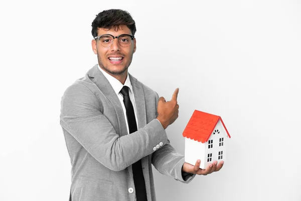 Uomo Affari Possesso Una Casa Isolata Sfondo Blu Che Punta — Foto Stock