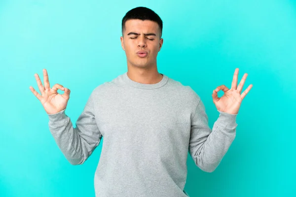 Ung Stilig Man Över Isolerad Blå Bakgrund Zen Pose — Stockfoto