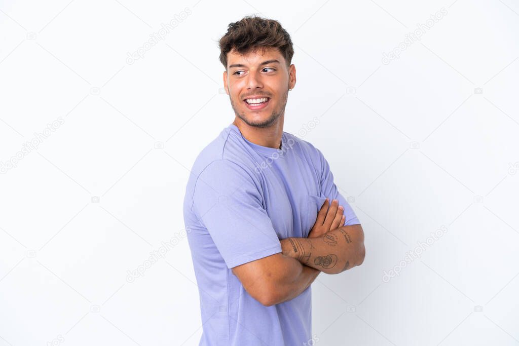 Young caucasian handsome man isolated on white background with arms crossed and happy