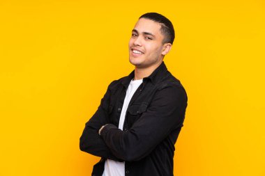 Asyalı yakışıklı adam sarı arka planda izole edilmiş şaşırmış ve ön tarafı işaret ediyor.