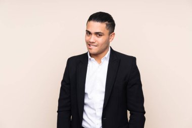 Asyalı iş adamı bej arka planda izole edilmiş. Şüpheleri var ve kafası karışmış bir yüz ifadesi var.