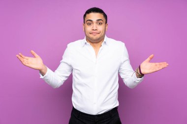 Asyalı yakışıklı adam mavi arka planda izole edilmiş ve ellerini kaldırırken kuşkuları var