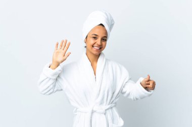 Bornozlu genç kadın izole edilmiş beyaz arka planda parmakları olan altı kişi sayıyor.