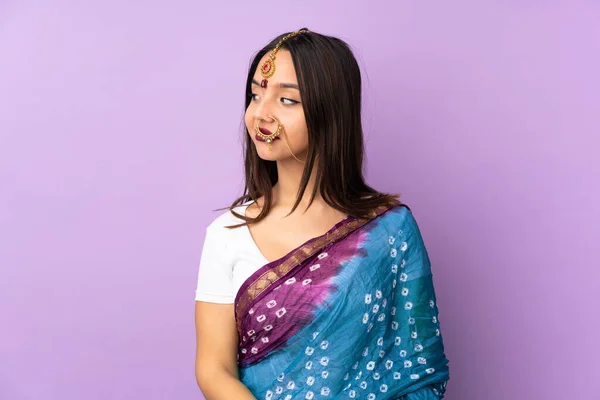 紫の背景に孤立した若いインド人女性側を見ながら疑問を持つ — ストック写真