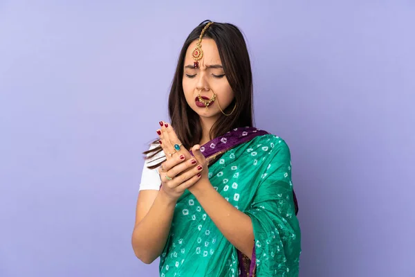 手の痛みに苦しんで紫色の背景に隔離された若いインド人女性 — ストック写真