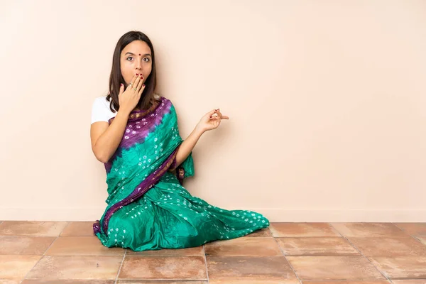 Young Indian Woman Sitting Floor Surprise Expression While Pointing Side — Stock Photo, Image