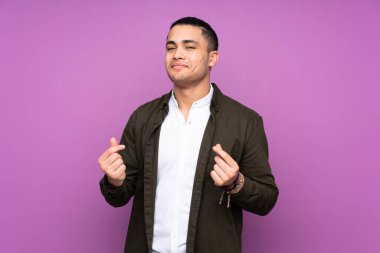 Asyalı yakışıklı adam mavi arka planda izole edilmiş para hareketi yapıyor.