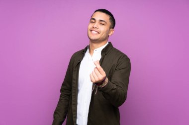 Asyalı yakışıklı adam mavi arka planda izole edilmiş para hareketi yapıyor.