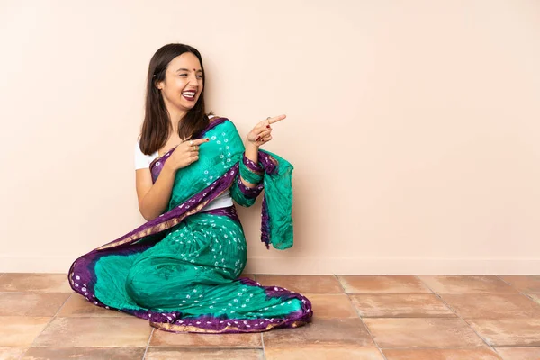 Νεαρή Ινδή Που Κάθεται Στο Πάτωμα Δείχνοντας Δάχτυλο Στο Πλάι — Φωτογραφία Αρχείου