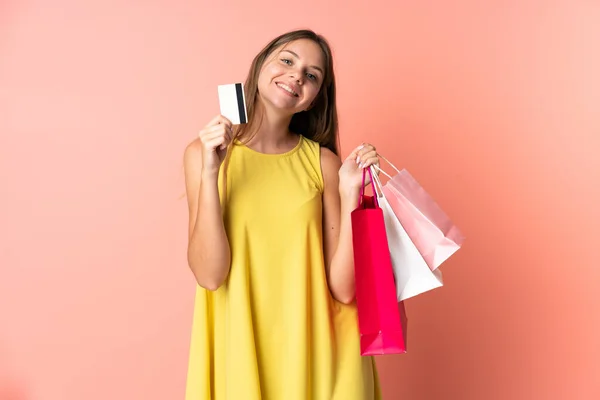 持购物袋和信用卡 身披粉色背景的立陶宛年轻女子 — 图库照片