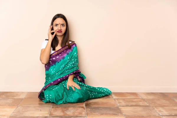 床に座っている若いインド人女性は沈黙のジェスチャーの兆候を示しています — ストック写真