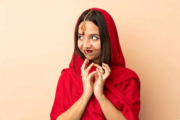 ベージュの背景に孤立した若いインド人女性が何かを計画 — ストック写真