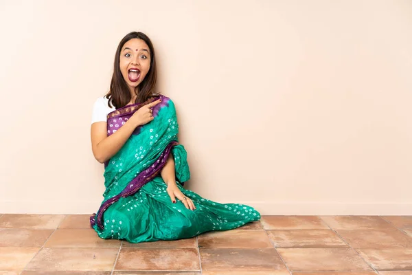 Young Indian Woman Sitting Floor Surprised Pointing Side — Stock Photo, Image