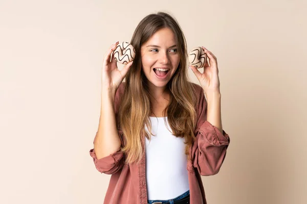 Young Lithuanian Woman Isolated Beige Background Holding Donuts Surprised — Stock Photo, Image