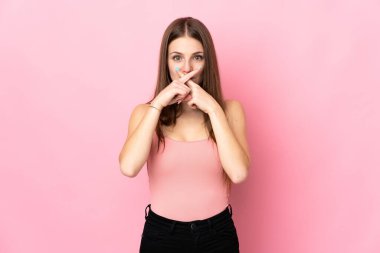 Pembe arka planda izole edilmiş beyaz bir kadın sessizlik işareti gösteriyor.