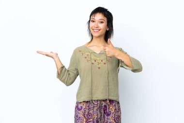 İzole edilmiş beyaz arkaplan üzerinde genç Uruguaylı kız bir ilan vermek ve onaylamak için avucunda hayali bir metin tutuyor.