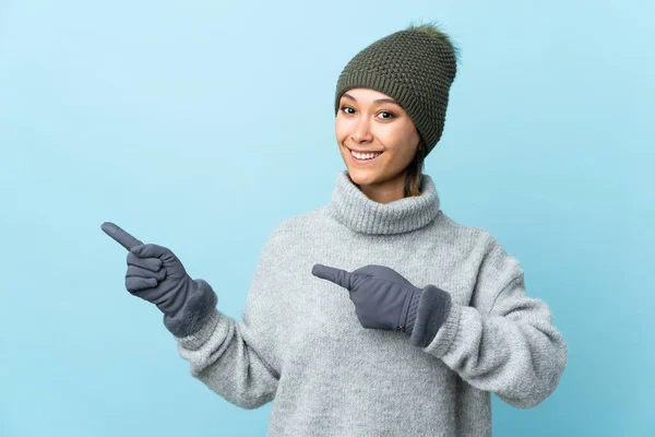 Joven Uruguaya Con Sombrero Invierno Aislado Sobre Fondo Azul Apuntando — Foto de Stock