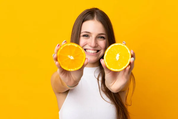 Młoda Biała Kobieta Trzymająca Pomarańczę Pomarańczowym Tle — Zdjęcie stockowe