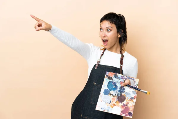 Joven Artista Sosteniendo Una Paleta Sobre Fondo Aislado Apuntando — Foto de Stock