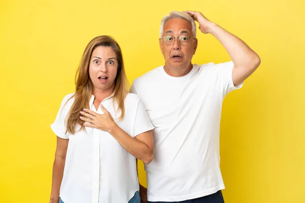 Paar Mittleren Alters Isoliert Auf Gelbem Hintergrund Mit Überraschendem Gesichtsausdruck — Stockfoto
