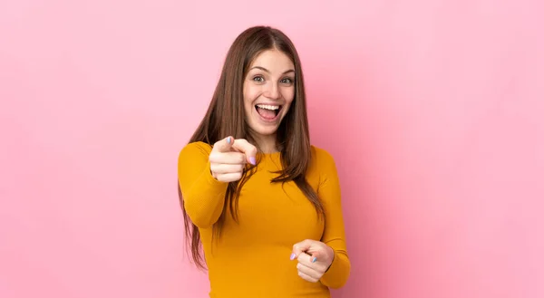 Mujer Joven Caucásica Aislada Sobre Fondo Rosa Sorprendida Apuntando Frente —  Fotos de Stock