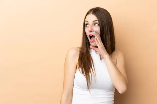 Young Caucasian Woman Isolated Beige Background Whispering Something Surprise Gesture — Stock Photo, Image