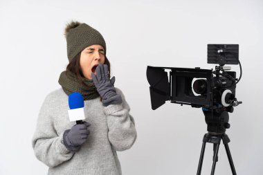 Muhabir kadın mikrofon tutuyor ve izole edilmiş beyaz arka planda esniyor ve ağzını eliyle kapatıyor.