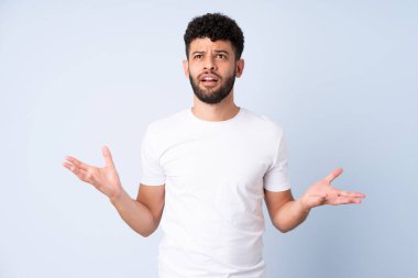 Faslı genç bir adam mavi arka planda izole edilmiş.