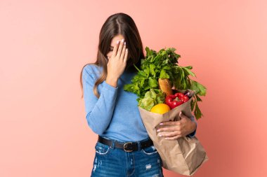 Litvanyalı genç bir kadın elinde bakkal poşeti tutarken yorgun ve hasta bir ifade vardı.