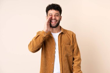 Bej arka planda izole edilmiş genç Faslı adam ağzı açık bağırıyor.