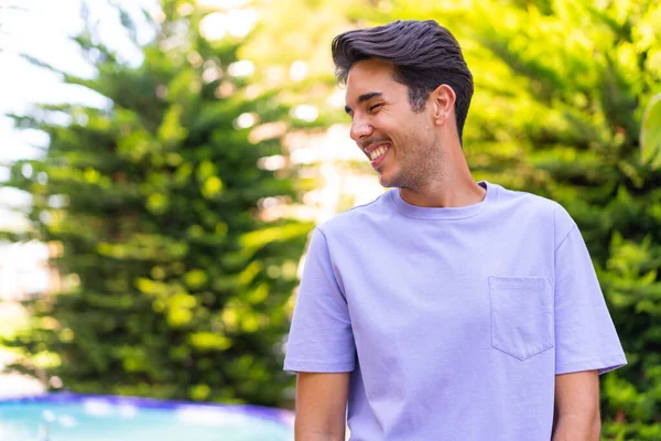 Açık havada genç beyaz bir adam Neşeli bir ifadeyle