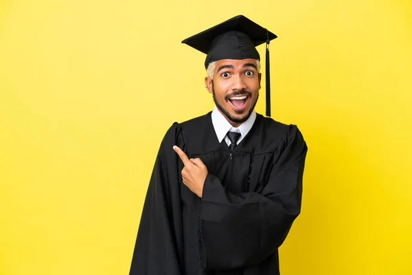 Genç Üniversite Mezunu Sarı Arka Planda Izole Edilmiş Şaşırmış Işaret — Stok fotoğraf