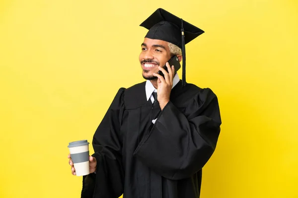 Junger Kolumbianischer Universitätsabsolvent Isoliert Auf Gelbem Hintergrund Mit Kaffee Zum — Stockfoto