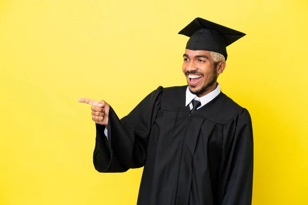 Junger Universitätsabsolvent Kolumbianischer Mann Isoliert Auf Gelbem Hintergrund Zeigt Mit — Stockfoto