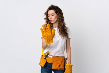 Genç elektrikçi beyaz arka planda izole edildi. Durma hareketi yapıyor ve hayal kırıklığı yaşıyor.