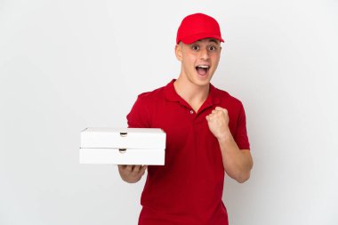 Pizza teslimatçısı üniformalı adam beyaz arka planda izole pizza kutularını topluyor. Kazanan pozisyonda zaferi kutluyor.