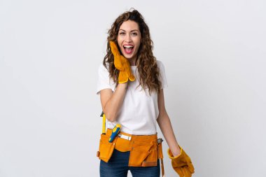 Genç elektrikçi beyaz arka planda mahsur kalmış, şaşırmış ve şok olmuş bir yüz ifadesi var.