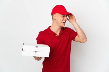 İş üniformalı bir pizzacı beyaz arka planda izole edilmiş pizza kutularını topluyor.