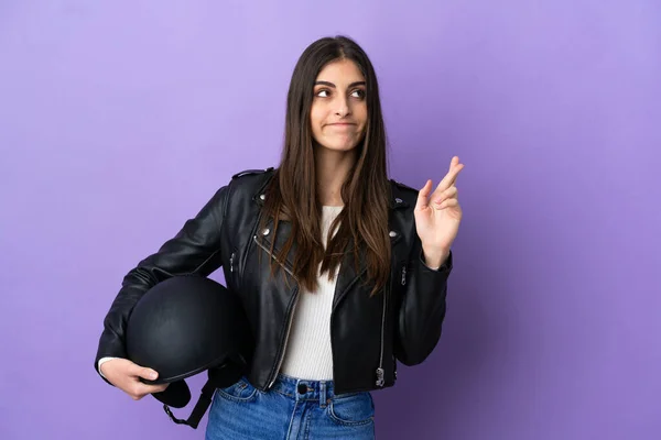 若いですCaucasian女性とともにオートバイヘルメット隔離上の紫色の背景に指交差と願って最高の — ストック写真
